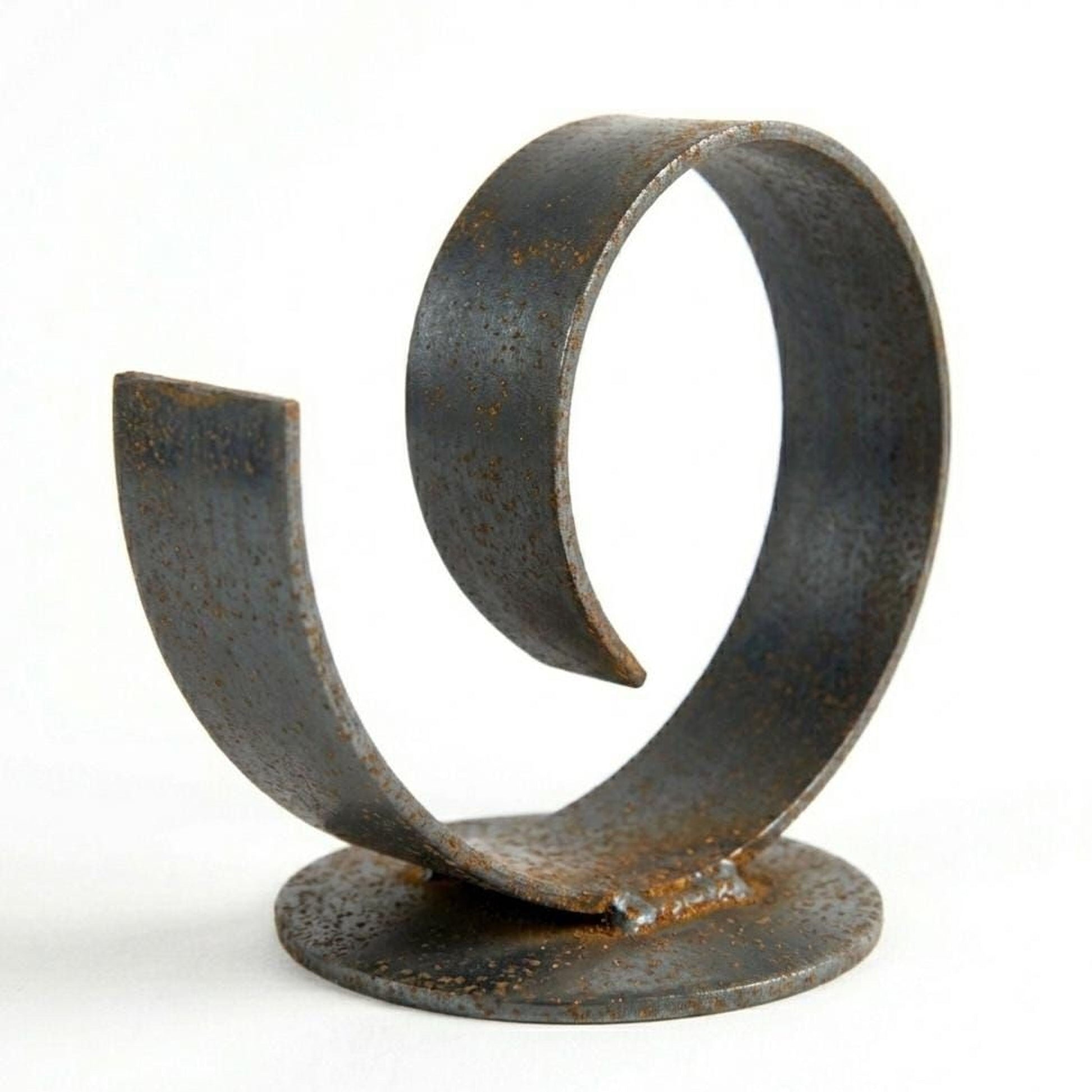 A spiral-shaped metal sculpture made of rusted metal, sitting on a round base.