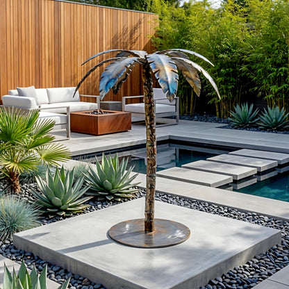 a modern outdoor living space with a large metal sculpture of a palm tree, surrounded by various plants and a small pool.