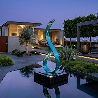 a modern house with a pool and a sculpture in the foreground, surrounded by lush greenery and palm trees.