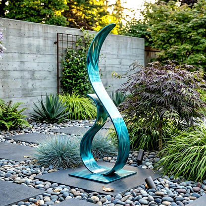 A modern, abstract sculpture in a garden setting, featuring a curved, metallic design with a blue-green hue.