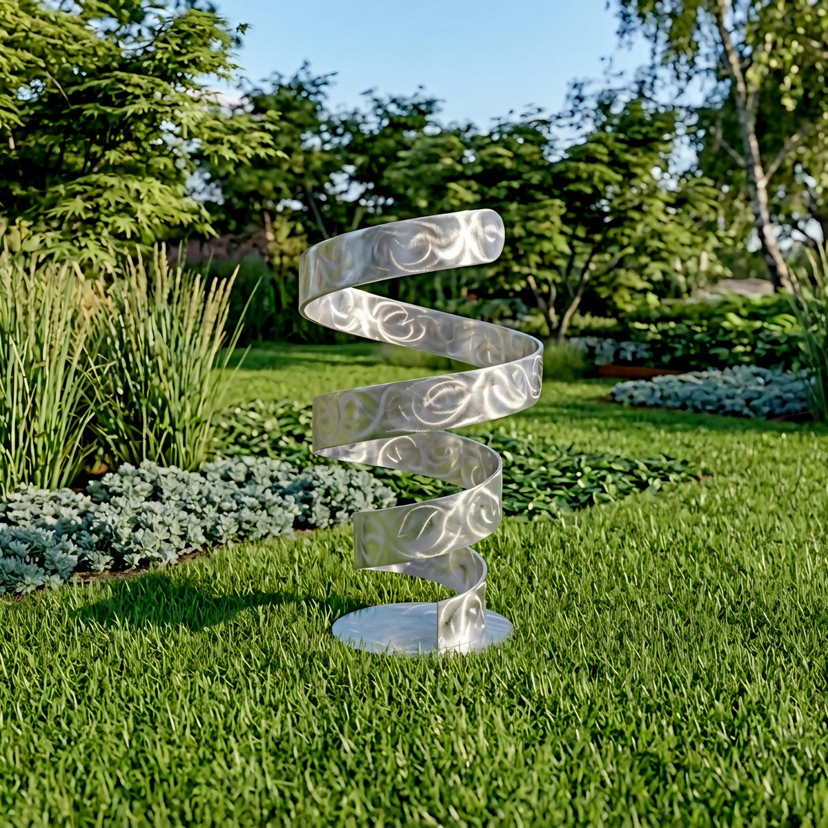 A silver spiral sculpture stands in a lush, green garden surrounded by various plants and trees.