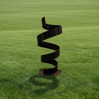 A black spiral sculpture stands in a grassy field, its intricate design contrasting with the surrounding greenery.
