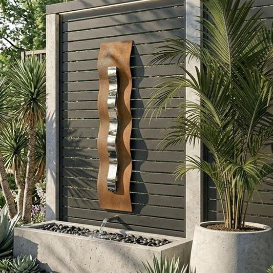 a modern outdoor garden design with a large metal sculpture and a concrete planter filled with rocks. The garden is surrounded by lush greenery, including palm trees and other tropical plants.