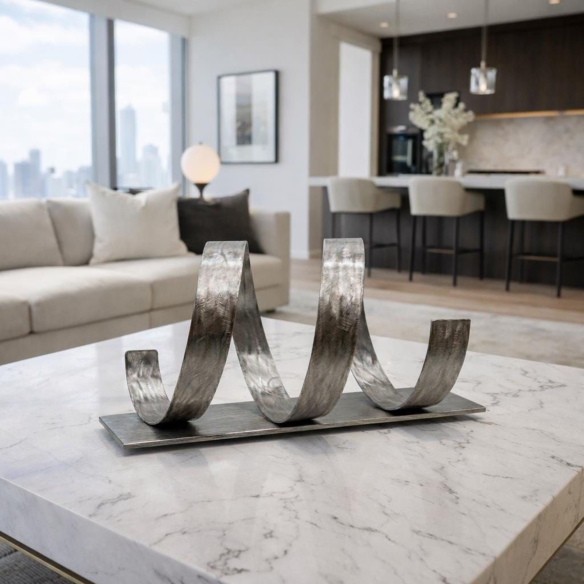 a modern living room with a marble-topped coffee table, a large window overlooking a city skyline, and a sleek metal sculpture on the table.