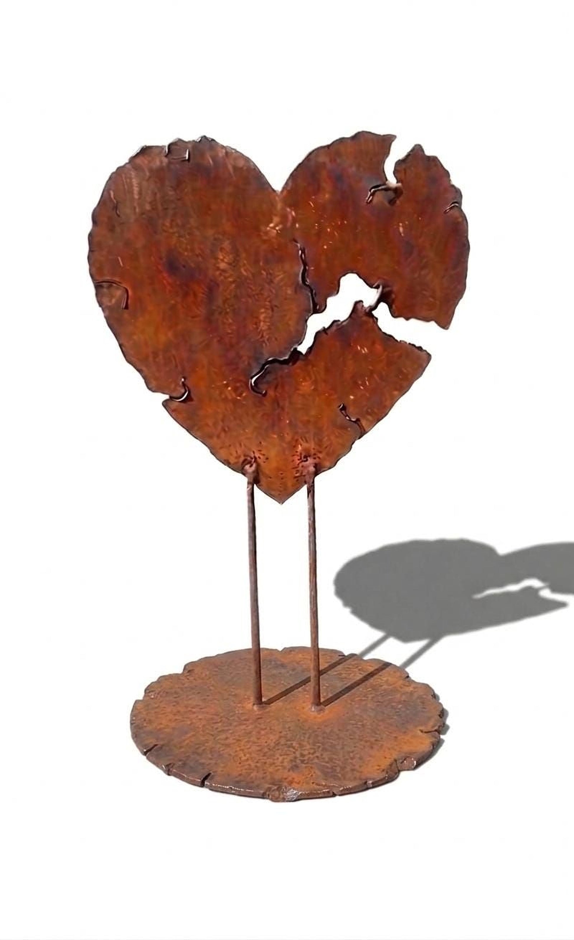 a rust-colored metal sculpture of a heart shape, with two thin metal rods supporting it.