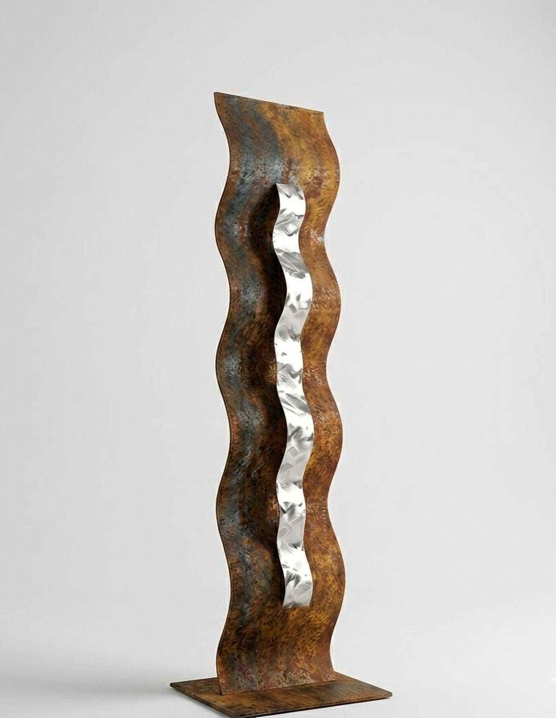 a tall, abstract sculpture made of metal, with a curved, wavy design and a metallic, silver-colored element attached to it.