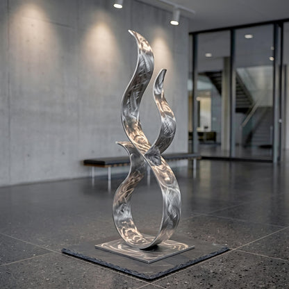 a modern, abstract sculpture composed of curved, metallic elements that create a dynamic and visually striking piece of art.