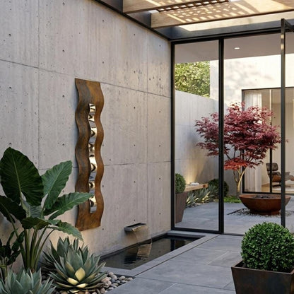 a modern outdoor space with a concrete wall, a glass door, and various plants and decorative elements.