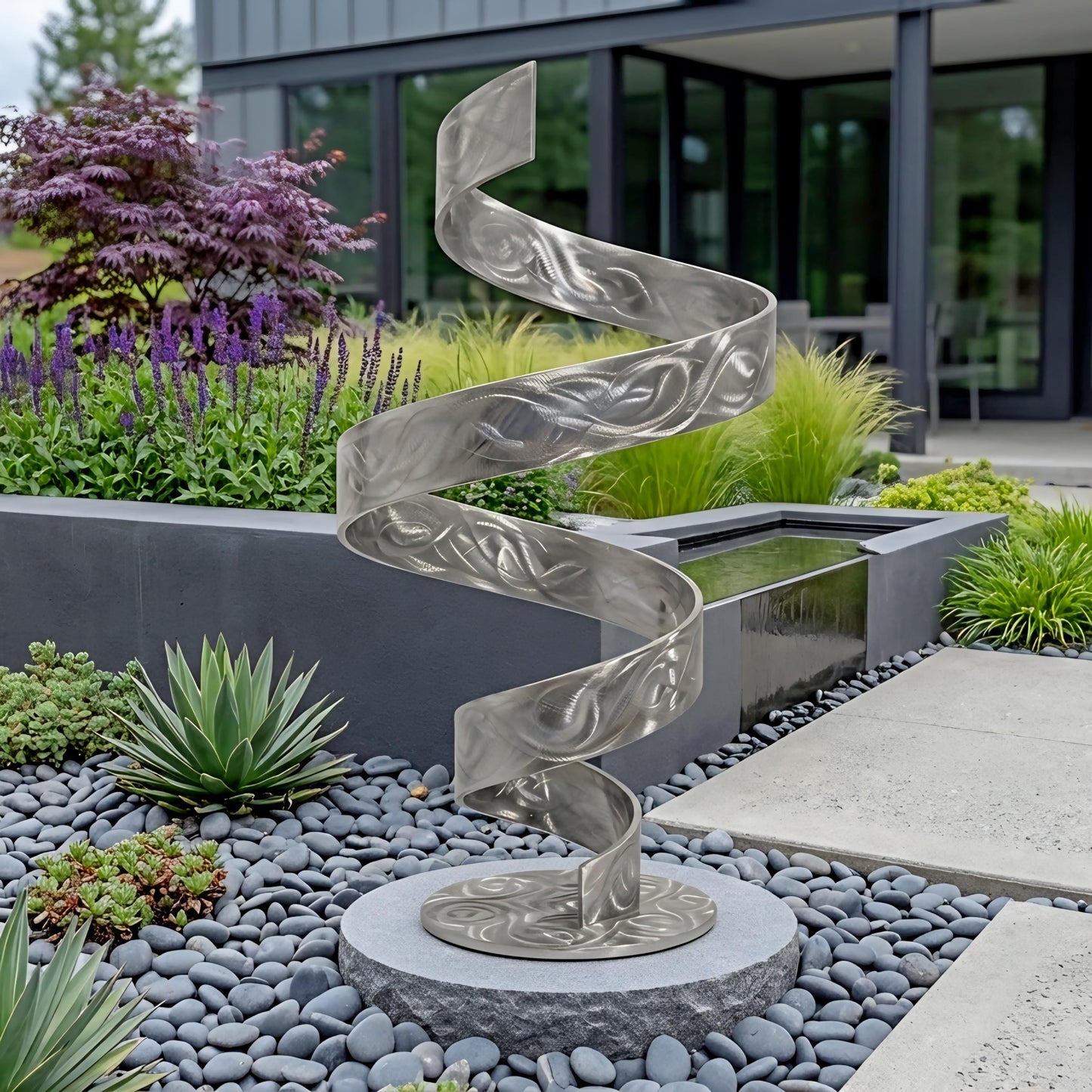 a modern, abstract metal sculpture with a spiral design, situated in a garden setting with various plants and a stone path.