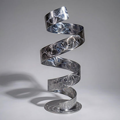 A spiral metal sculpture with a repeating pattern of circles and lines, standing on a round base.