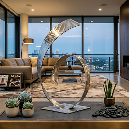 a modern living room with a large curved metal sculpture as the focal point. The room has a large window that provides a view of the city skyline, and the space is decorated with various items such as a potted plant, a vase, and a stack of books.