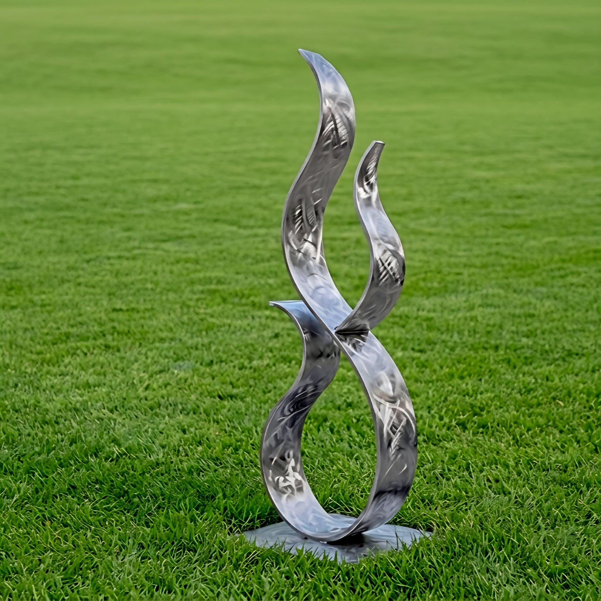 A metal sculpture resembling a flame or fire stands on a grassy field.