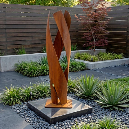 a modern garden sculpture with a unique, abstract design, situated in a well-maintained garden with various plants and a wooden fence.