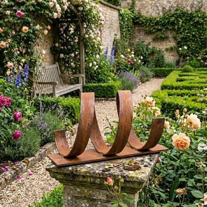 A rustic metal sculpture in a lush garden, surrounded by vibrant flowers and greenery.