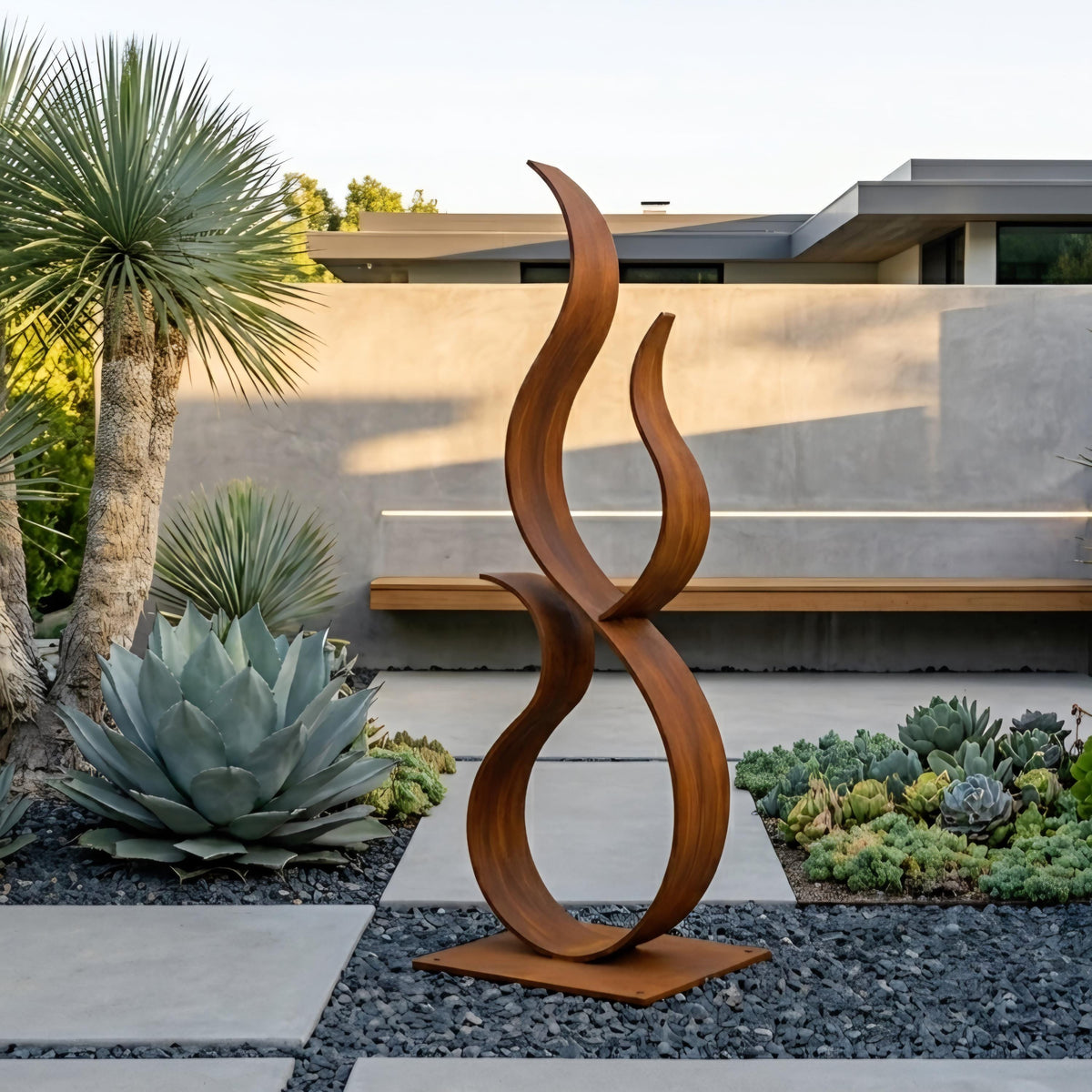 a modern outdoor sculpture with a unique, abstract design, situated in a garden setting with various plants and a building in the background.