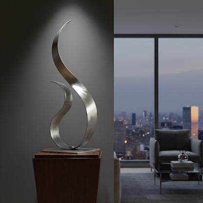 a modern, minimalist living room with a large window offering a view of a city skyline at dusk. The room is furnished with a sofa, a coffee table, and a sculpture on a wooden pedestal.
