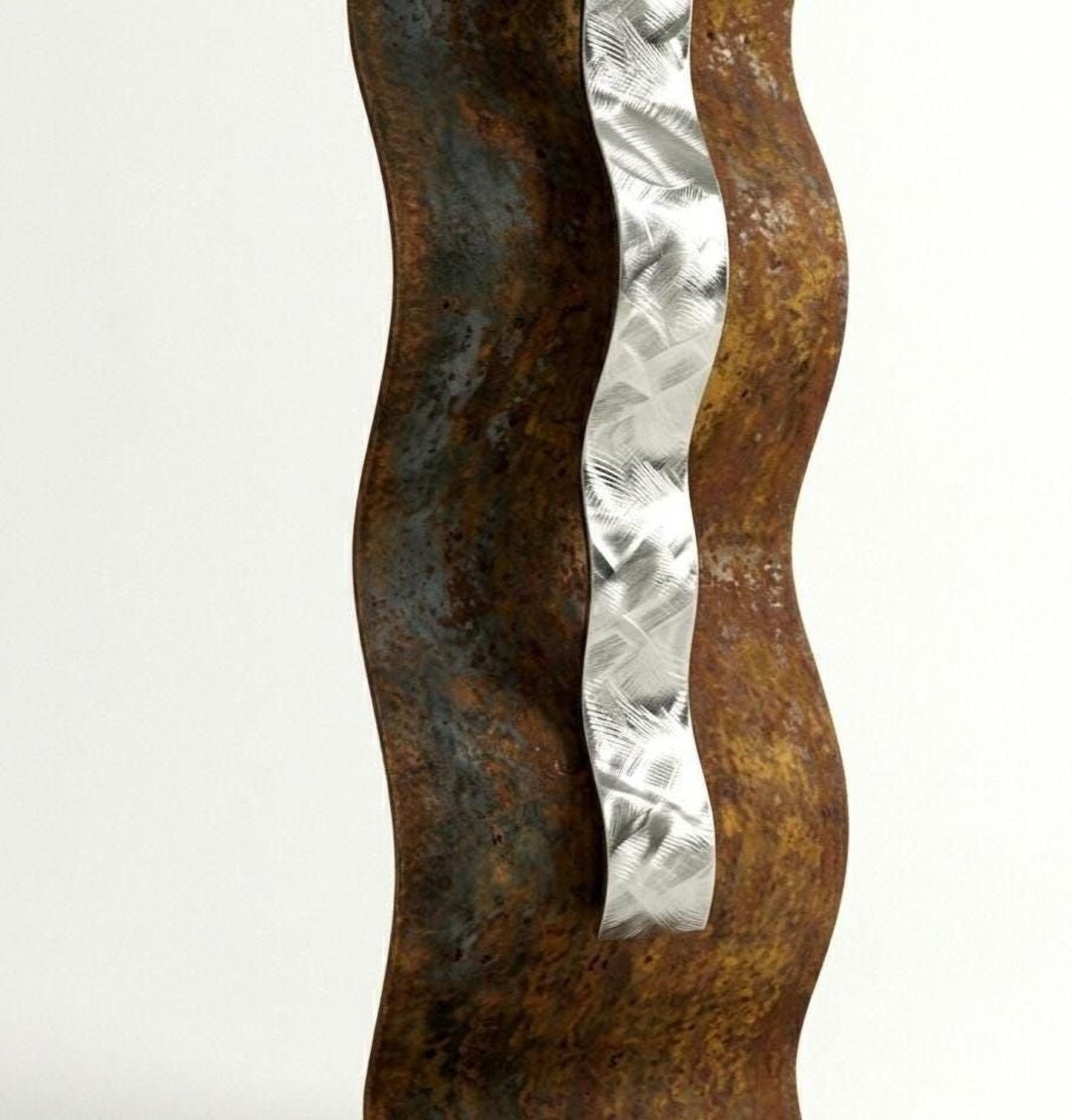 a close-up view of a rusted metal sculpture with a vertical metal strip or ribbon attached to it.