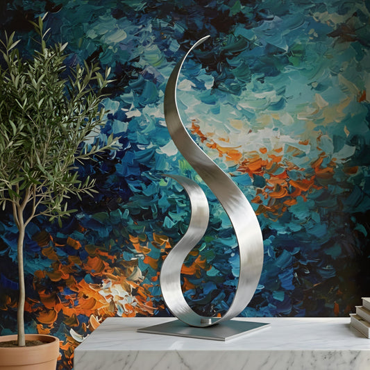 a modern, abstract sculpture with a curved, metallic design, placed on a marble surface. The background is a vibrant, colorful painting with brushstrokes that create a sense of movement and energy.
