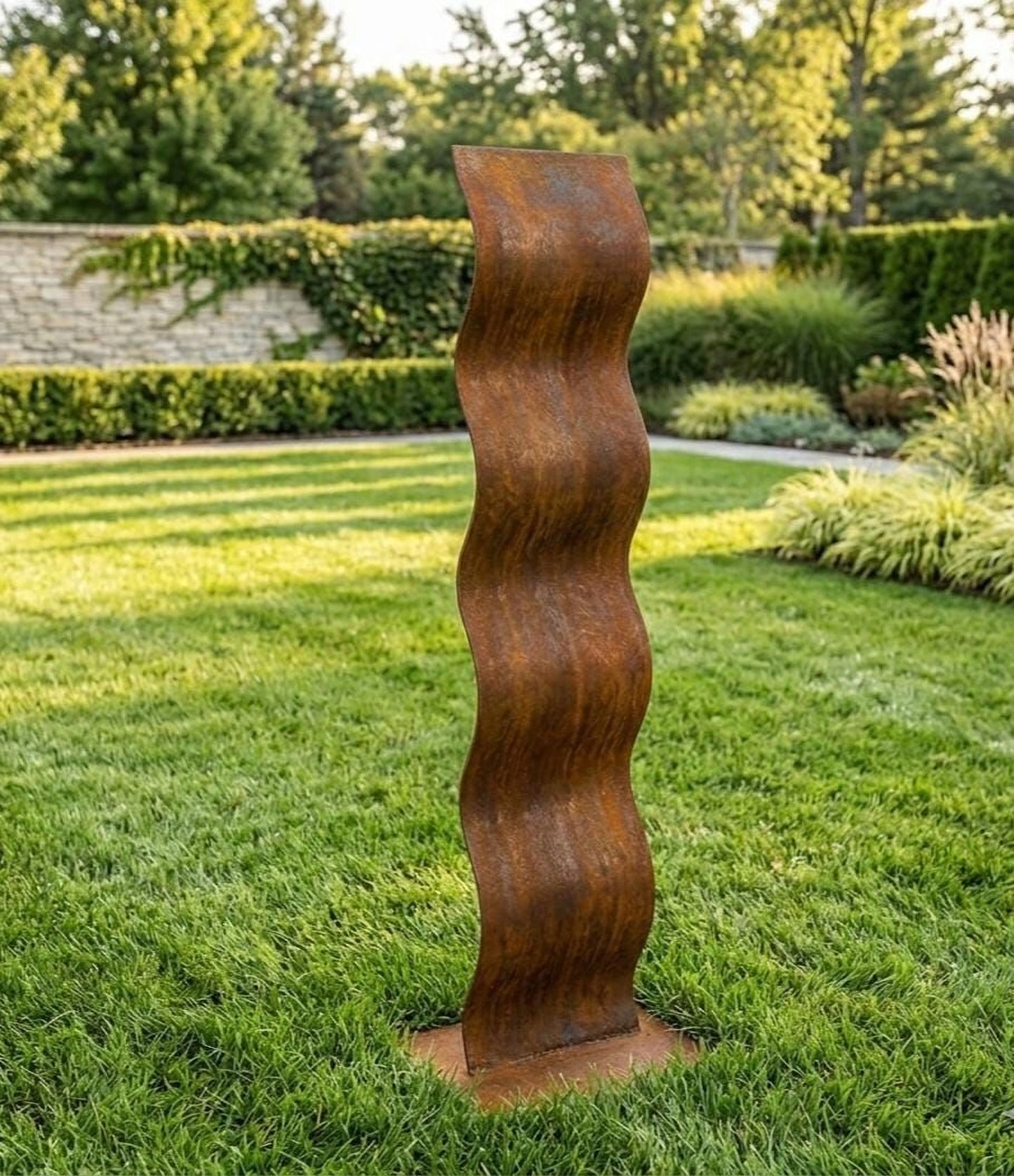 a tall, rust-colored metal sculpture standing in a well-maintained, lush green lawn.