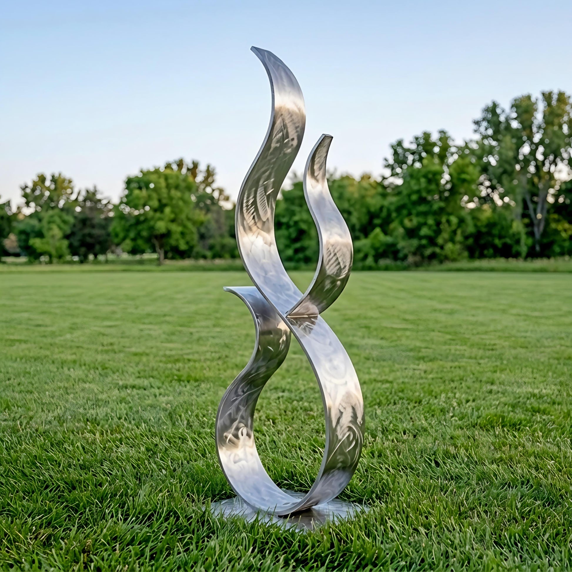 A large, abstract metal sculpture resembling a flame or fire stands in a grassy field, with trees visible in the background.
