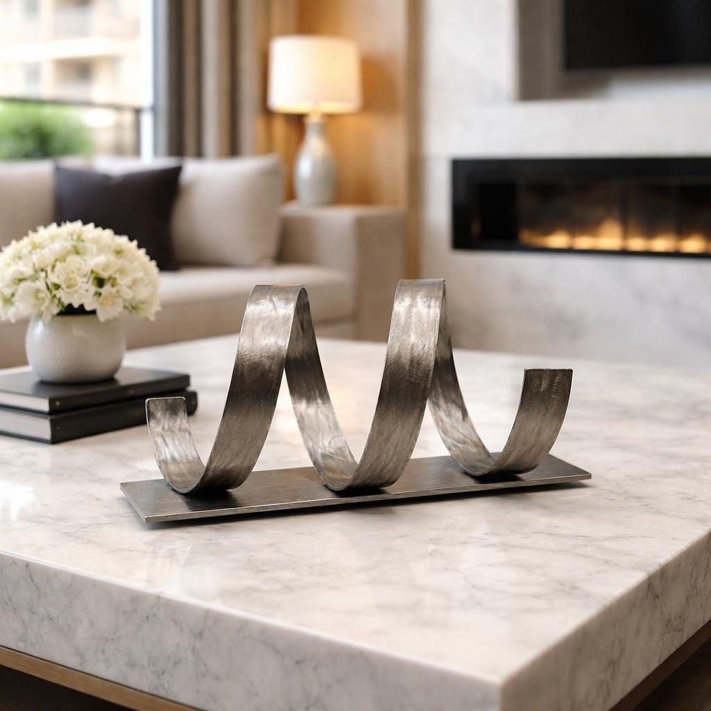 a modern living room with a marble table, a decorative metal sculpture, a lamp, and a fireplace.