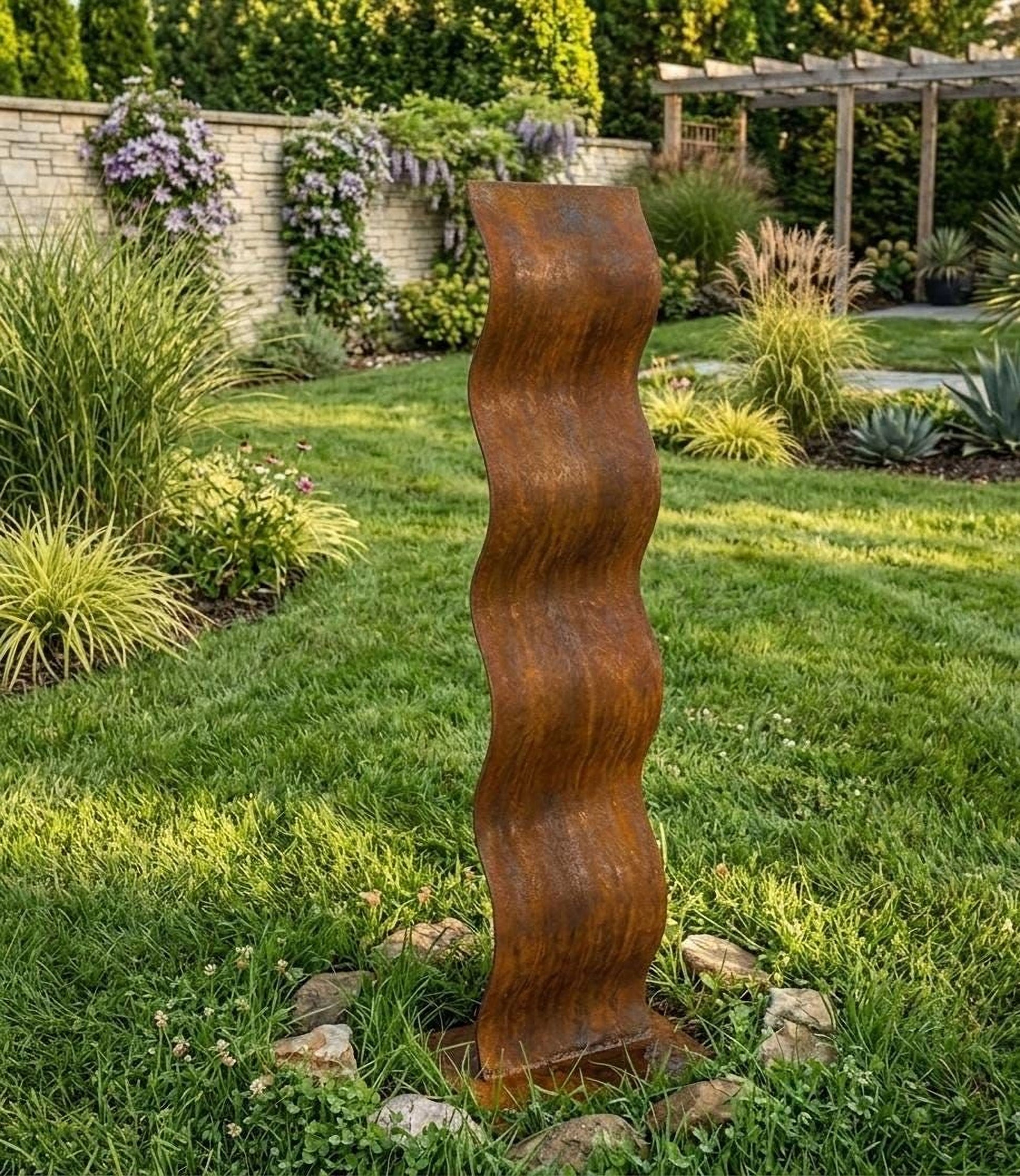 a tall, rust-colored metal sculpture standing in a lush, well-maintained garden.