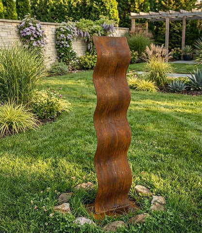 a tall, rust-colored metal sculpture standing in a lush, well-maintained garden.