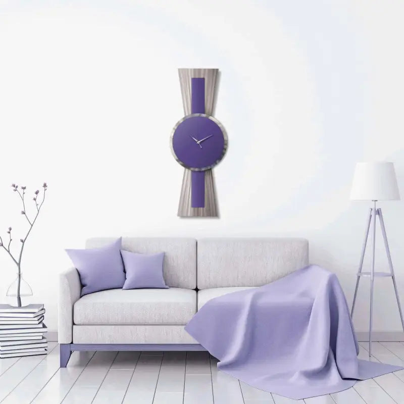 a white couch with a purple blanket and a clock on the wall